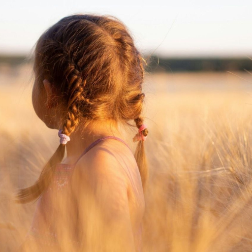 Petite fille dans un champ au printemps, illustrant des idées douces pour accompagner les émotions des enfants avec Noundoll.